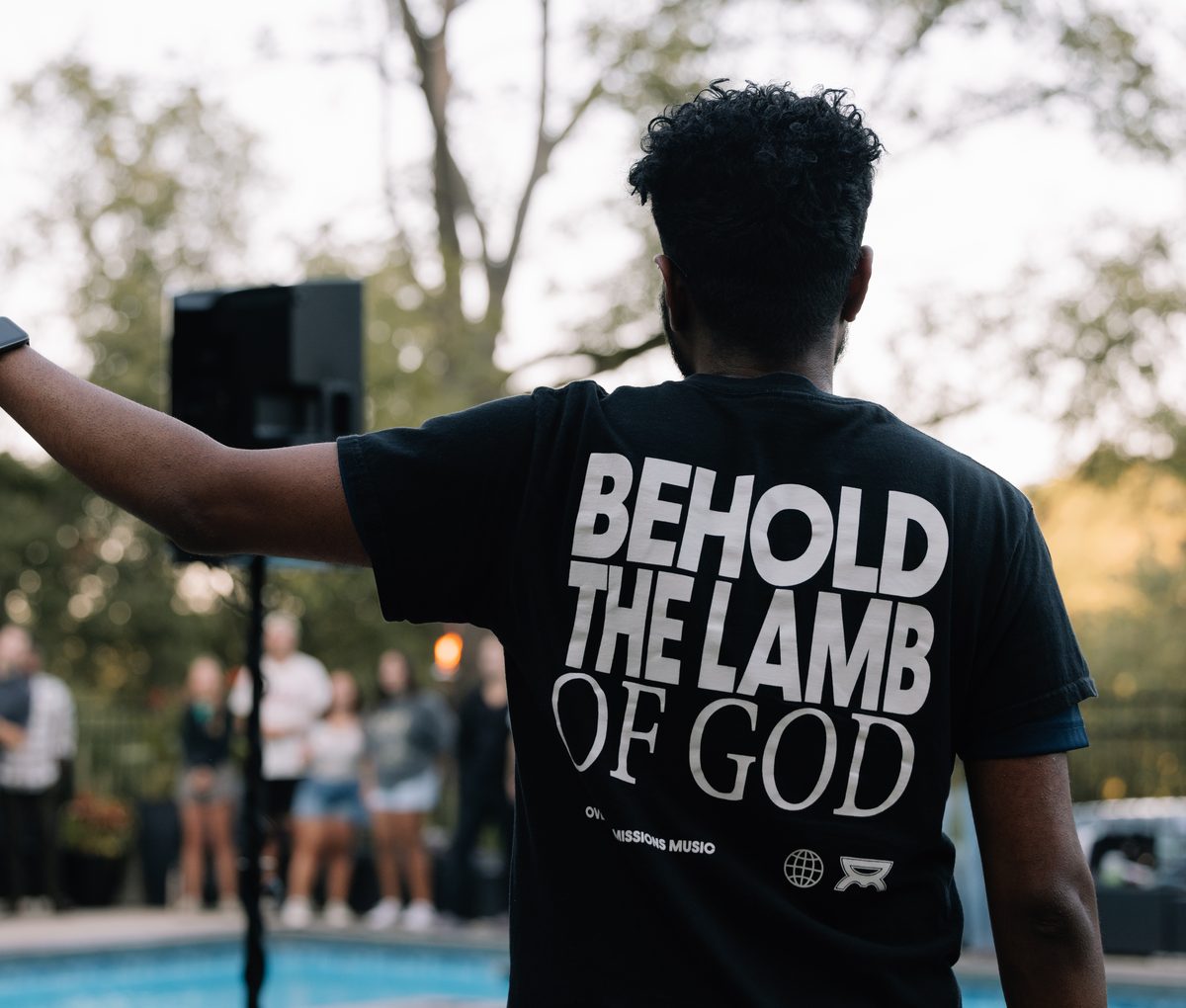 A worshipper with arm raised, Behold the Lamb of God